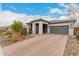 This lovely single-story home features brick driveway, neutral color palette, and desert landscaping at 8751 S 168Th Dr, Goodyear, AZ 85338