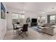 Bright living room with hardwood floors, a modern chandelier and a large sectional couch at 8751 S 168Th Dr, Goodyear, AZ 85338