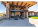 Covered patio with stone columns, an outdoor fireplace, and comfortable lounge furniture at 8751 S 168Th Dr, Goodyear, AZ 85338