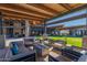 Outdoor patio area with comfortable seating and a concrete fire pit in a landscaped backyard at 8751 S 168Th Dr, Goodyear, AZ 85338