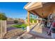 Relaxing covered patio area with porch swing, manicured yard, and lush foliage in backyard at 950 E Desert Inn Dr, Chandler, AZ 85249