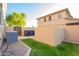 View of the backyard featuring a stone perimeter, grass, and an AC unit on the side of the home at 950 E Desert Inn Dr, Chandler, AZ 85249