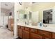 Well-lit bathroom boasts double sinks, wooden cabinets, and a large mirror perfect for a growing Gathering at 950 E Desert Inn Dr, Chandler, AZ 85249