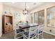 Dining room with wooden table and white chairs, bathed in natural light from nearby windows at 950 E Desert Inn Dr, Chandler, AZ 85249