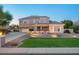 Charming two-story home with stone accents, well-lit landscaping, and a lush green lawn at 950 E Desert Inn Dr, Chandler, AZ 85249