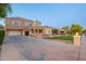 Expansive driveway leads to a charming two-story home with lush green lawn and mature landscaping at 950 E Desert Inn Dr, Chandler, AZ 85249