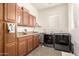 Well-lit laundry room features washer, dryer, utility sink, granite countertop, and wood cabinets at 950 E Desert Inn Dr, Chandler, AZ 85249