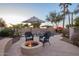 Inviting outdoor pool area at dusk features a fire pit, patio umbrellas, and lush landscaping at 950 E Desert Inn Dr, Chandler, AZ 85249