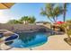 Lush pool area with rock waterfall, lush landscaping, and refreshing blue water at 950 E Desert Inn Dr, Chandler, AZ 85249