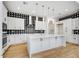 Modern kitchen with white cabinets, a large island, and a stylish black-and-white backsplash at 100 W Northern Ave # 4, Phoenix, AZ 85021