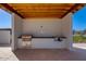 Well-equipped outdoor kitchen with built-in grill, counter space, and a wooden pergola at 100 W Northern Ave # 4, Phoenix, AZ 85021