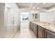 Bathroom boasting a glass shower, double vanity with granite counters, and an open view to the bedroom at 26949 W Lone Cactus Dr, Buckeye, AZ 85396