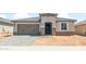 Charming single-story home with a gray tile roof, a two-car garage, and a covered entryway at 26949 W Lone Cactus Dr, Buckeye, AZ 85396