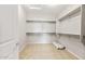 Walk-in closet featuring carpet flooring, shelving and rod system, and a neutral color palette at 26949 W Lone Cactus Dr, Buckeye, AZ 85396