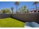 Backyard artificial grass with palm trees and wrought iron fence at 300 N Gila Springs Blvd # 144, Chandler, AZ 85226