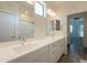 Bright bathroom featuring double sink vanity, brushed nickel fixtures, and a view of the bedroom and glass shower at 300 N Gila Springs Blvd # 144, Chandler, AZ 85226