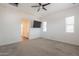 Bright bedroom features neutral carpet, ceiling fan, TV, and plenty of natural light through two windows at 300 N Gila Springs Blvd # 144, Chandler, AZ 85226