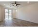 Bright bedroom featuring a ceiling fan, wood-look flooring, and a glass sliding door at 300 N Gila Springs Blvd # 144, Chandler, AZ 85226