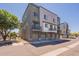 Modern townhome featuring a private balcony, gray paint scheme, and individual garages at 300 N Gila Springs Blvd # 144, Chandler, AZ 85226