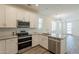 Modern kitchen featuring stainless steel appliances, white cabinets, and stone countertops at 300 N Gila Springs Blvd # 144, Chandler, AZ 85226