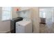 Well-lit laundry room includes a washer and dryer, storage shelf, and tile floor at 300 N Gila Springs Blvd # 144, Chandler, AZ 85226