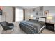 Comfortable bedroom with black and white accents, a patterned bedspread, and a gray chair at 10543 E Sahuaro Dr, Scottsdale, AZ 85259