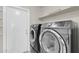 Modern laundry room features front loading washer and dryer with shelf and white door at 10543 E Sahuaro Dr, Scottsdale, AZ 85259