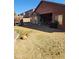 A spacious backyard with a tan dog resting in the sun and a covered patio at 11590 W Cocopah St, Avondale, AZ 85323