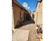 View of side yard with block-paved path, rock landscaping and gate to back of property at 11590 W Cocopah St, Avondale, AZ 85323