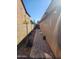 View of a block-paved side yard with block wall and exterior of home at 11590 W Cocopah St, Avondale, AZ 85323