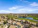 An aerial view showcases a golf course and lake nestled in a vibrant residential community with mountain views at 1248 E Briarwood Ter, Phoenix, AZ 85048