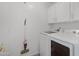 Functional laundry room with white washer, dryer, and overhead cabinetry at 1248 E Briarwood Ter, Phoenix, AZ 85048