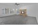 Spacious living room with a stone fireplace, ceiling fan, and multiple windows allowing plenty of natural light at 1248 E Briarwood Ter, Phoenix, AZ 85048