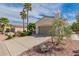 Beautiful desert home featuring lush landscaping and palm trees and a two-car garage at 12835 W Chapala Ct, Sun City West, AZ 85375