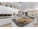 Spacious kitchen with granite counters, modern appliances, tile backsplash and sleek white cabinets at 12835 W Chapala Ct, Sun City West, AZ 85375