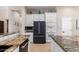 Modern kitchen boasts granite counters, stainless steel appliances, white cabinetry, and tile flooring at 12835 W Chapala Ct, Sun City West, AZ 85375