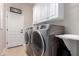 Convenient laundry room with modern washer and dryer set, ample counter space, and overhead cabinets for storage at 12835 W Chapala Ct, Sun City West, AZ 85375