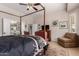 Spacious main bedroom with four-poster bed, hardwood floors, lounge chairs, and ensuite bathroom access at 12835 W Chapala Ct, Sun City West, AZ 85375