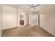 Bedroom with neutral walls, carpet, and ceiling fan is open to the bathroom with arched doorway at 14575 W Mountain View Blvd # 621, Surprise, AZ 85374