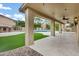 Expansive covered patio with ceiling fans overlooks a pristine pool and lush landscaping at 14841 N 62Nd Way, Scottsdale, AZ 85254