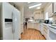 Bright kitchen featuring wood flooring, white appliances, and light wood cabinetry at 17200 W Bell Rd # 1643, Surprise, AZ 85374