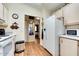 Bright kitchen featuring wood flooring, white appliances, and a view into the hallway and bedroom at 17200 W Bell Rd # 1643, Surprise, AZ 85374