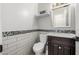 Powder room featuring a sink with dark cabinets, wall tiling, and white walls at 18543 E Purple Sage Dr, Queen Creek, AZ 85142