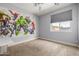 Bedroom features an accent wall with superhero decoration with carpet flooring at 18543 E Purple Sage Dr, Queen Creek, AZ 85142
