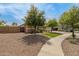 Charming home exterior with desert landscaping, green lawn, and a view of the walkway at 18543 E Purple Sage Dr, Queen Creek, AZ 85142