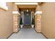 Inviting front entrance with stone pillars, decorative plants, and a welcoming wreath on the door at 18543 E Purple Sage Dr, Queen Creek, AZ 85142