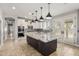 Modern kitchen with white cabinets, a large island with pendant lights, and stainless steel appliances at 18543 E Purple Sage Dr, Queen Creek, AZ 85142