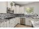 This modern kitchen features white cabinets, mosaic tile backsplash, and stainless steel appliances at 18543 E Purple Sage Dr, Queen Creek, AZ 85142