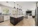 Open-concept kitchen with center island flows into living area with fireplace and backyard access at 18543 E Purple Sage Dr, Queen Creek, AZ 85142
