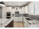 Beautiful kitchen showcasing stainless steel appliances, mosaic backsplash, granite countertops, and white cabinets at 18543 E Purple Sage Dr, Queen Creek, AZ 85142